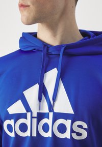 adidas Sportswear SPORTSWEAR HOODED TRACKSUIT SET - Tuta - semi lucid blue/black