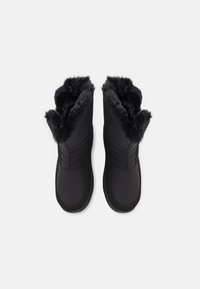 Sorte vinterstøvler med myk faux fur-fôr, teksturerte sider og rund tådesign. Har en lavprofil og polstret såle.