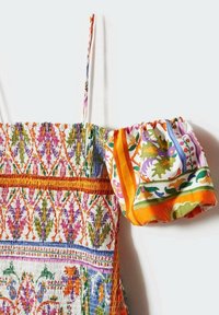 Robe smockée colorée avec des motifs floraux complexes en orange, rose, vert et violet ; comprend des bretelles spaghetti réglables et une manche assortie.