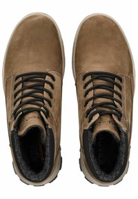 Botas de cuero marrón hasta el tobillo con cordones negros, una superficie texturizada y forro de felpa. Cuentan con una plantilla acolchada y suelas de goma.