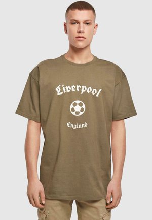 Oliven grønn bomull t-skjorte med ribbet tekstur, med et hvitt "Liverpool"-logo og fotballgrafikk, samt "England"-tekst under.