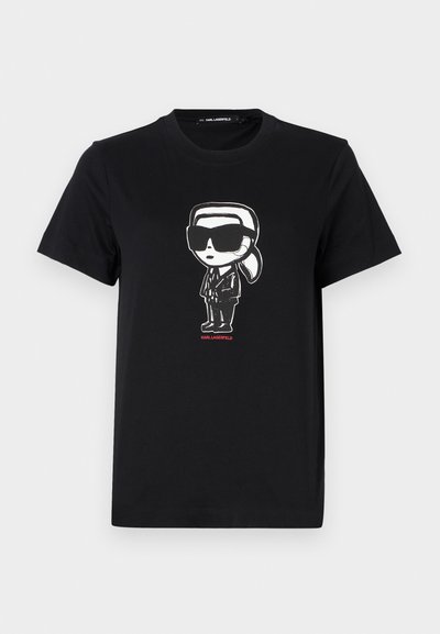 Черна памучна тениска с графика на фигура в слънчеви очила и костюм. Просто дизайнерско деколте с къси ръкави. Червен текст отдолу.