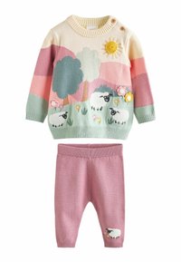 Sweter z wełny z wielokolorowym wzorem owiec, słońca i drzew; zestawiony z różowymi dzianinowymi spodniami z detalem owcy. Oba elementy wykonane z miękkiego materiału.