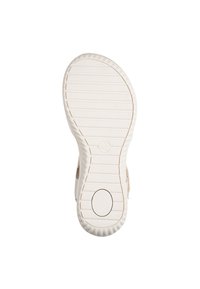 Suola di una scarpa con una superficie in gomma testurizzata, caratterizzata da linee orizzontali e un accento circolare al centro. Il colore è un beige chiaro con una finitura liscia.