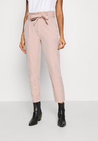 Ljust rosa skräddarsydda byxor med bälte och hög midja, med en texturerad tyg och rak, ankellång skärning, tillsammans med svarta ankla stövlar.