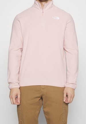 Light pink fleece pullover with a half-zip collar, featuring a white logo on the left chest and long sleeves. Soft texture and casual fit.