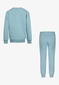 Ljusblå sweatshirt och matchande byxor, båda gjorda av ett slätt tyg. Sweatshirten har långa ärmar och ribbade ärmslut; byxorna har ett elastiskt midjeband.