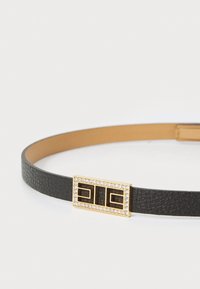Black leather belt with a textured finish, featuring a gold buckle adorned with clear rhinestones and geometric details.