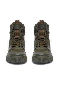 Pár vysokých olivovozelených tenísk s hrubými rebrovanými podrážkami, šnúrkami a označením na jazyku, orientovaných spredu na bielom pozadí.