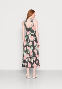 Vestido midi com estampa floral em fundo preto, decote halter e costas abertas. O tecido é suave com uma textura lisa. Acentuado com flores em tons de rosa e verde.