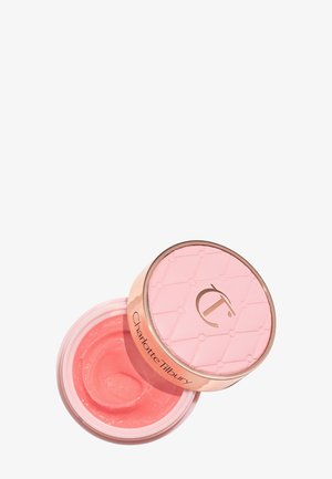 Pink cosmetic balm in a clear jar with a textured blush lid, embossed with a logo. Smooth, glossy texture visible inside.