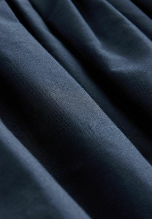 Tumedat sinine kangas, millel on sile tekstuur, millel on peened voldid ja kortsud, näidates ühtlast värvi ilma mustrite või kaunistusteta.