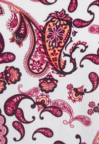 Tecido branco com intrincados padrões de paisley e florais em tons de vermelho, rosa e laranja, com contornos e detalhes ousados por toda a parte.