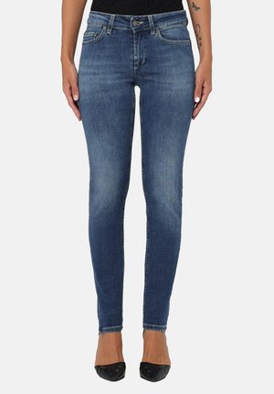 Slanke blå jeans lavet af denim med en falmet vask, der har fem lommer, bæltesløjfer og lynlås. Båret med sorte spidse hæle.
