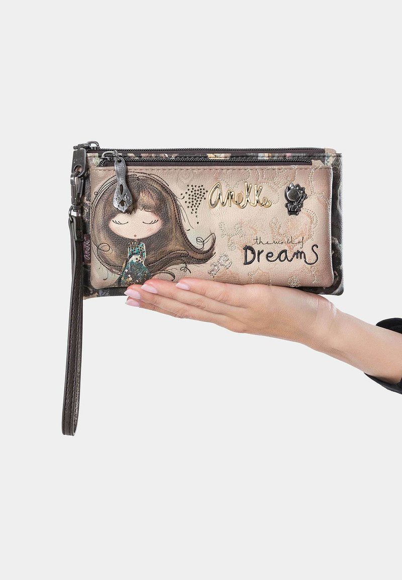 Cartera con un diseño ilustrado colorido que presenta a una chica con cabello castaño. Cierre de cremallera, correa de muñeca desmontable y acentos dorados.