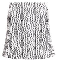 Jupe blanche avec un motif tribal géométrique noir présentant des lignes verticales et des formes de diamant en zigzag.