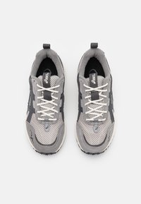 Grijze sportschoenen met een ademende mesh bovenkant, suède accenten en contrasterende zwarte overlays. Vetersluiting met een versterkte neus.