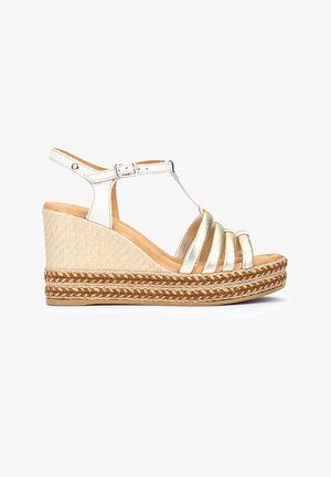 Sandalia de cuña con parte superior de cuero metálico dorado, plataforma de yute trenzado y tira en el tobillo. Detalle trenzado intrincado a lo largo de la suela.