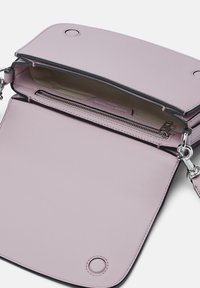 Jasnoróżowa skórzana torebka crossbody z zamkiem błyskawicznym, zatrzaskiem i srebrnymi akcentami. Wnętrze ma gładkie beżowe wykończenie.