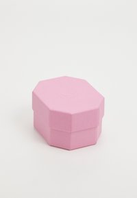 Boîte octogonale rose avec une finition texturée, dotée d'un couvercle qui s'ajuste parfaitement au corps. Pas de matériel ou de motifs visibles.