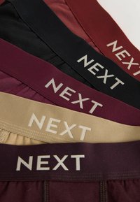 Cinq paires de ceintures de sous-vêtements pour hommes en noir, rouge foncé, marron, beige et bordeaux, chacune avec "NEXT" imprimé sur les bandes.