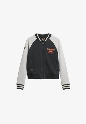 Zwart-grijze bomberjack met ritssluiting aan de voorkant, geribbelde manchetten en een logo op de borst. Heeft contrasterende mouwen en een zachte textuur.