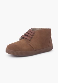 Bottines en daim marron avec un bout arrondi, un laçage à l'avant et une semelle en caoutchouc texturée. Doublure intérieure lisse pour un confort supplémentaire.
