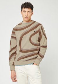 Felpa beige con motivi a spirale marroni, dotata di colletto rotondo e polsini a coste. Piccolo emblema di un albero sul lato sinistro del petto. Mistura di cotone.