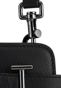 Gros plan sur un sac à main en cuir noir avec des ferrures en argent poli. Présente un design épuré, des détails de couture remarquables et un fermoir à crochet.