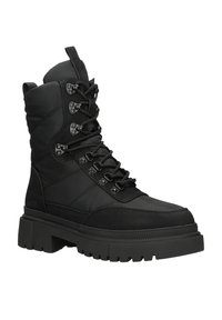 Czarny botek na kostkę z wyściełanym wierzchem, sznurowanym przodem, metalowymi oczkami oraz grubą gumową podeszwą z teksturowanym wzorem.
