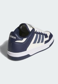 Námornícky modré a biele tenisky vyrobené z textúrovanej kože, s klasickým dizajnom, trojprúžkovými akcentmi a gumovou podrážkou.