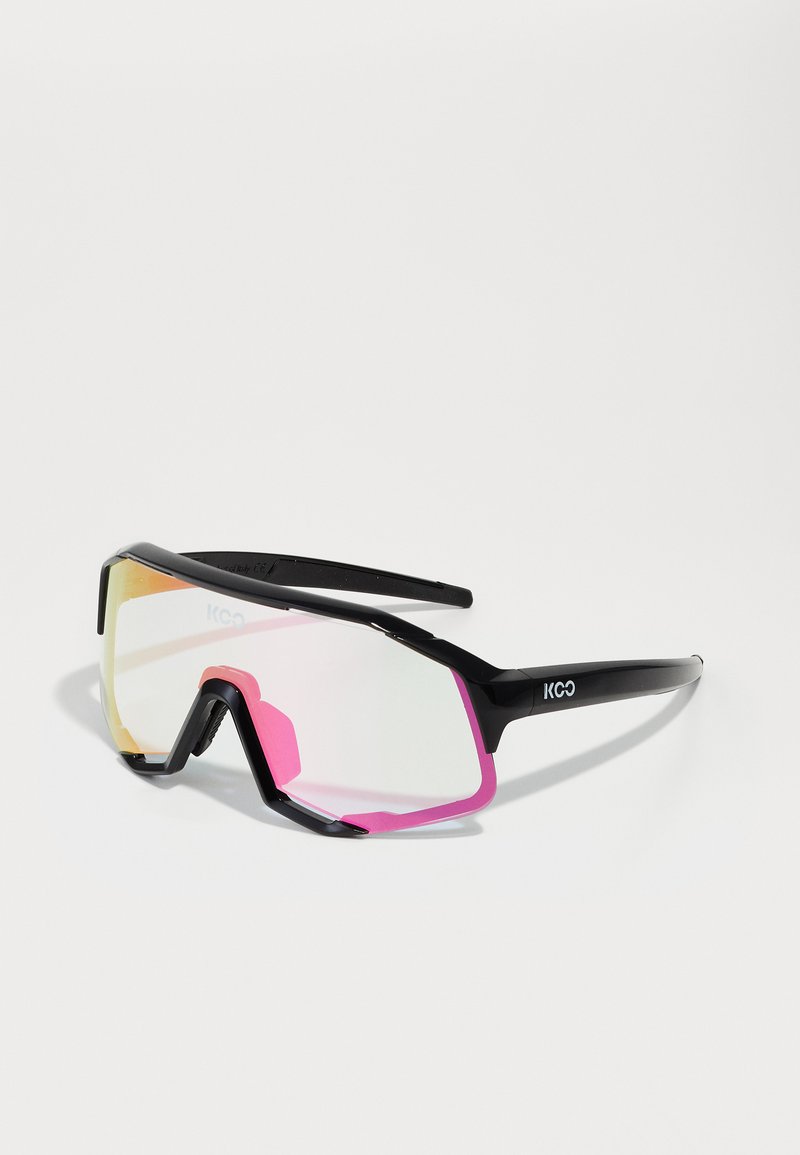 Occhiali da sole sportivi con montatura nera, dettagli rosa e lenti riflettenti a gradiente. Caratterizzati da un design audace e angolare per una maggiore visibilità.