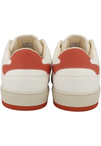 White leather sneakers with red accents, featuring a rounded toe, padded collar, and thick beige rubber sole. Notable stitching on the upper.
