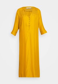 Żółta długa sukienka z gładkiego materiału, z dekoltem w kształcie litery V, marszczonymi detalami, guzikami z przodu i rękawami o długości trzech ćwiartek.