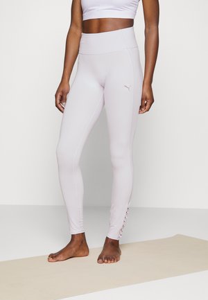 Leggings de cintura alta em rosa claro, feitos de um tecido elástico, com um logótipo subtil, costuras verticais e franzido decorativo no tornozelo.