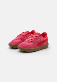 Červené a růžové sportovní boty s vrškem z síťoviny a semiše, silnou gumovou podrážkou a texturovanými detaily. Obsahují šňůrky a logo Puma.