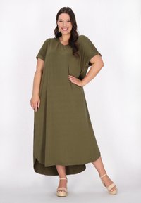 Rochie maxi verde măsliniu cu mâneci scurte, decolteu rotund și slituri laterale. Purtați cu sandale cu platformă bej. Textură netedă, croi lejer.