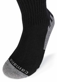 Calzino nero con una trama a coste, dotato di punta e tallone grigi con marchio nero. Il design è alla caviglia.