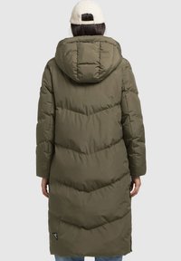 Cappotto lungo imbottito verde oliva con cappuccio, caratterizzato da una texture a cerniera a forma di V e un piccolo logo del marchio sull'orlo laterale.
