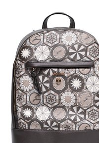 Zaino in pelle marrone caratterizzato da una parte frontale con motivo geometrico composto da esagoni e disegni circolari nei toni crema, beige e marrone. Dettaglio con tasca con cerniera.