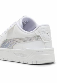 Biele syntetické tenisky s iridescenčným logom Puma a akcentmi, zaoblenou špičkou, textúrovanou podrážkou a polstrovaným golierom.