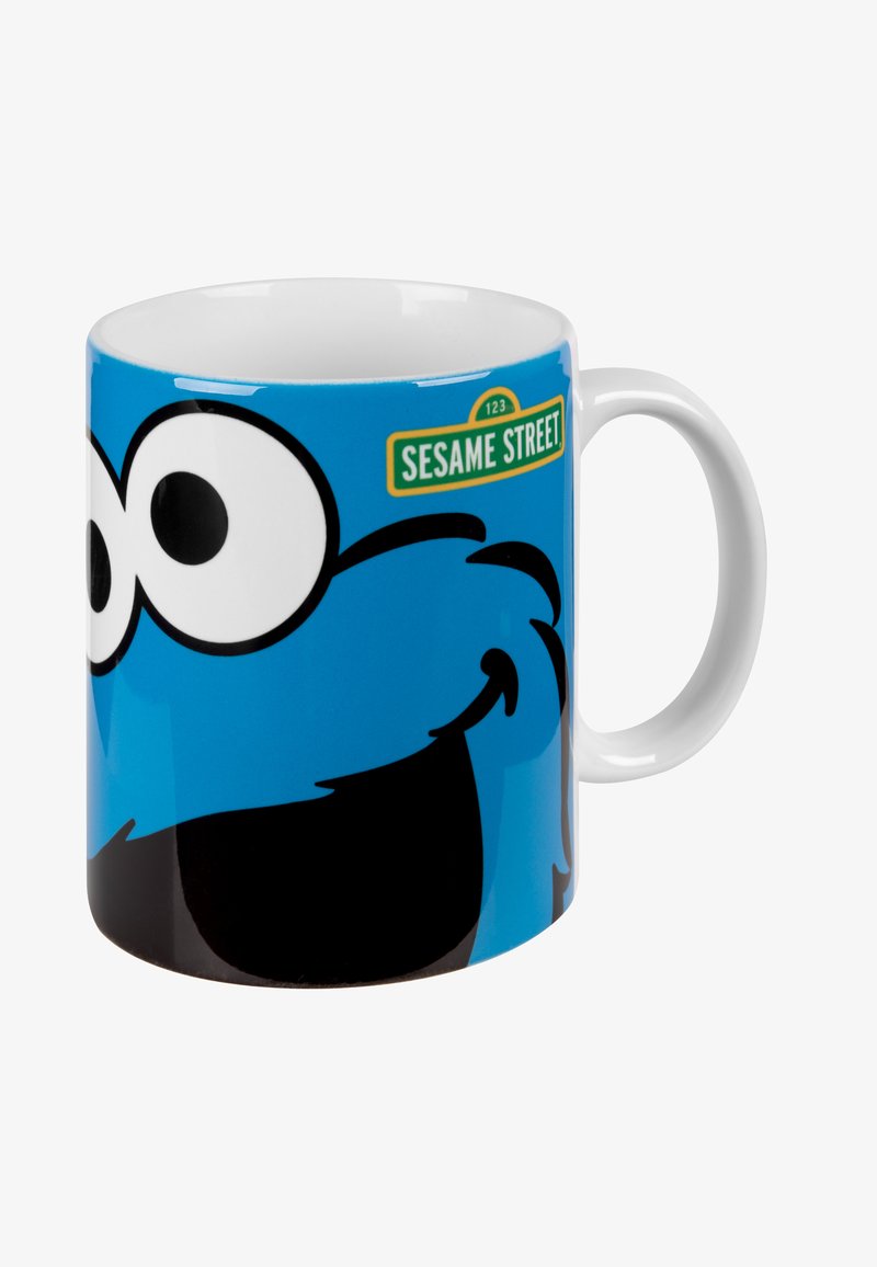 Mug in ceramica con sfondo blu e design del personaggio Cookie Monster in stile cartoon, con grandi occhi e bocca nera, etichettato "Sesame Street."
