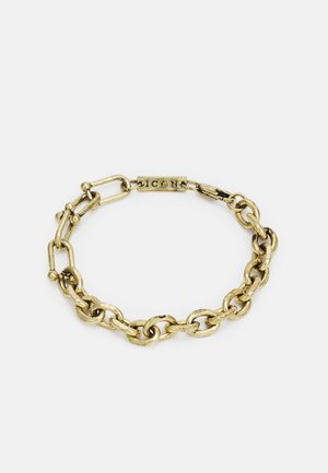 Pulseira de metal dourado com elos ovais e redondos, com um acabamento texturizado e um fecho marcado "ICON." Design durável em estilo corrente.