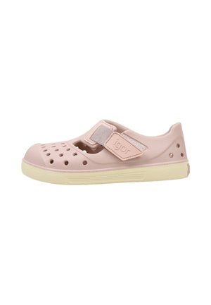Zapato de agua de goma rosa claro con perforaciones, correa ajustable de velcro con la etiqueta "igor" y suela beige.