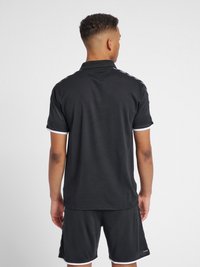 Sort polo skjorte med korte ærmer og krave, prydet med hvid kant og et struktureret stof, parret med sorte shorts.