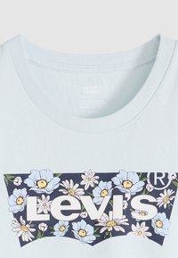 Ανοιχτό μπλε βαμβακερό μπλουζάκι με ναυτικό σχέδιο λουλουδιών και το κείμενο «Levi's» σε λευκό, στρογγυλή λαιμόκοψη, κοντά μανίκια, ομαλή υφή.