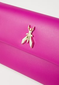 Ljusrosa clutch i slät material med en guldinsektsformad accent framtill med fint detaljerad design.