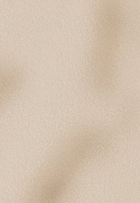 Beige textiel met een zachte, matte oppervlakte, met een subtiel fijn korrelpatroon over het geheel. Egaal van kleur zonder zichtbare naden.