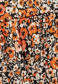 Blumiger Stoff mit schwarzem Hintergrund und orangen, weißen und cremigen Blumen. Glatte Textur mit gerafften Designelementen.