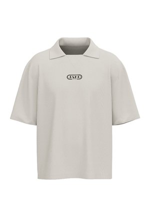 Beige polo med korte ærmer, bred krave og lille sort mærkelogo midt på brystet.